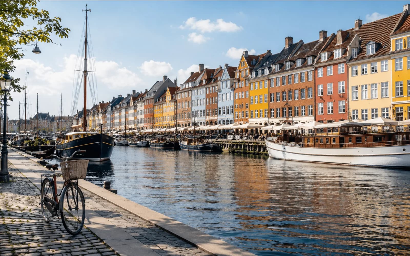 Copenhagen-style Danish canal waterfront with colorful buildings, boats and a bicycle